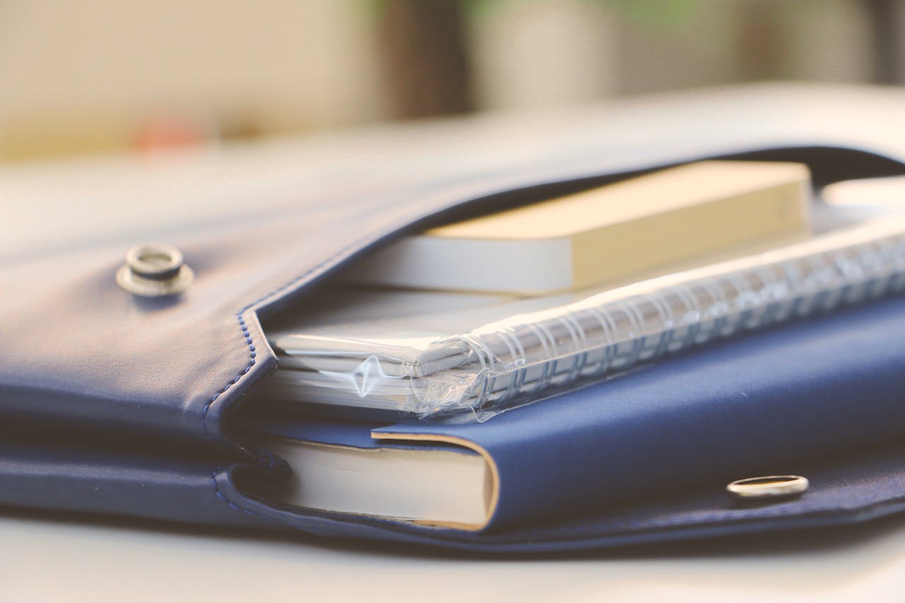our-story Close-up of a stylish blue portfolio containing various notebooks, creating an organized office look.